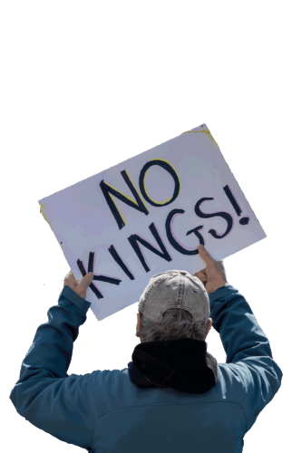 A man in a denim jacket holding a No Kings sign